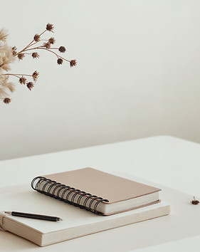 minimalist-desk-setup-with-dried-flowers-notebooks-pen.jpg