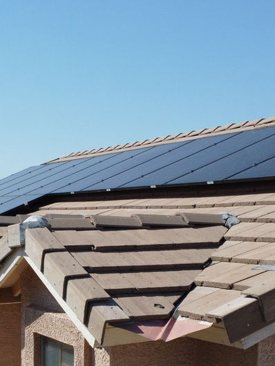 Solar panels on a Phoenix Arizona rooftop under intense summer sun with blue sky