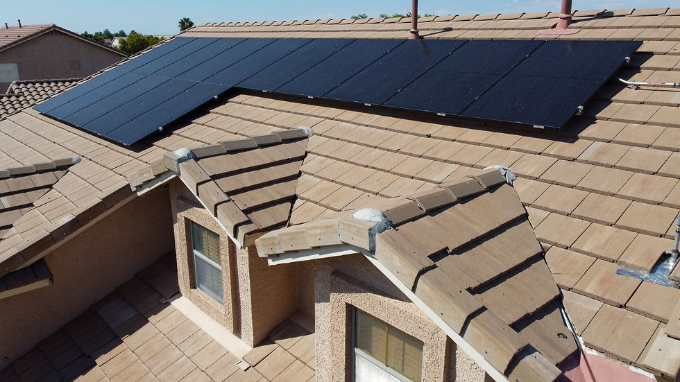 Phoenix homeowner comparing APS solar rate plans on laptop with solar panels visible on roof