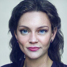 A middle-aged woman. Pale Caucasian, wavy black hair, blue eyes.