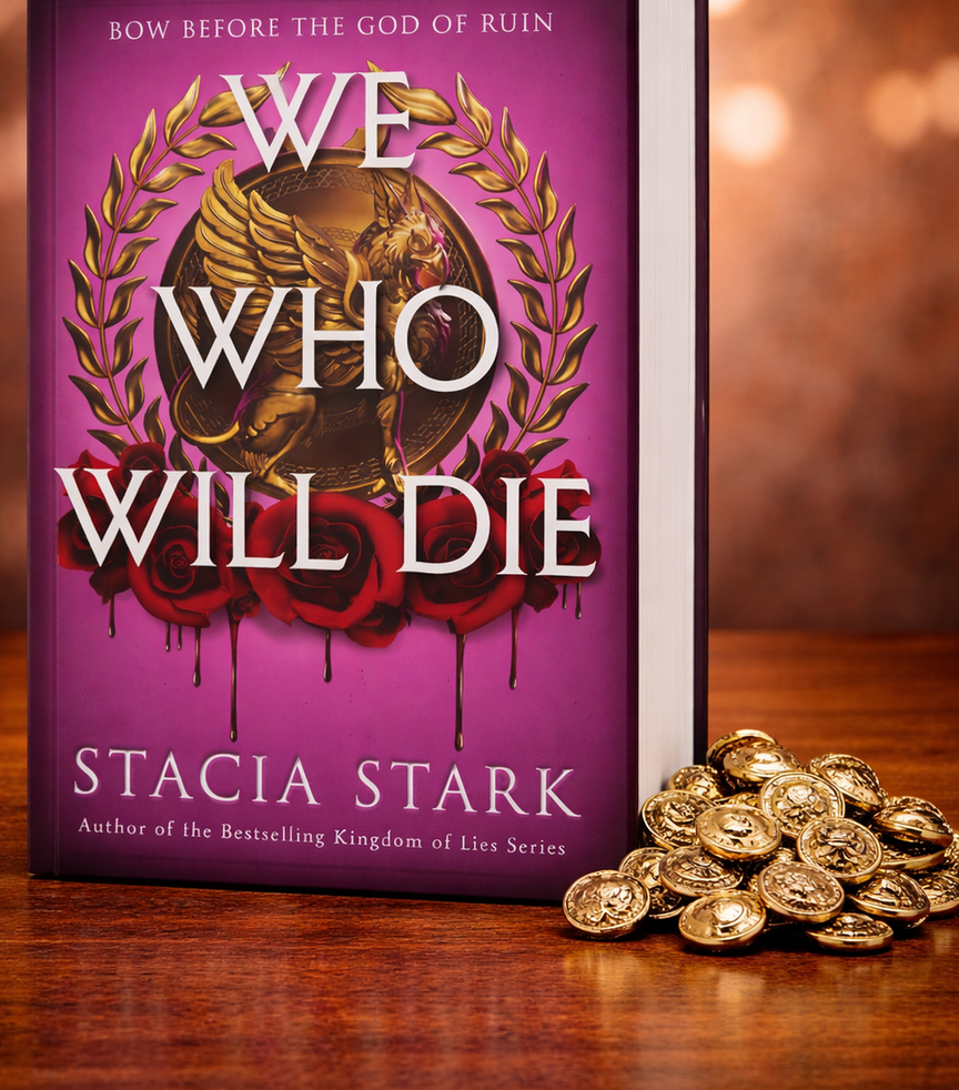 Purple book "We Who Will Die" by Stacia Stark on a wooden table, gold coins beside it. Cover features a golden laurel and roses.
