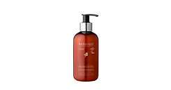 Natulique Nourishing Conditioner in matte beige bottle with clean white label, styled on a wooden surface with soft natural light and green plant elements.