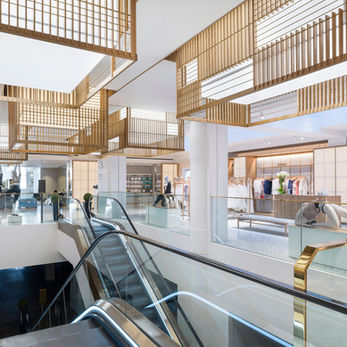 Interior view of Selfridges Body Studio with Japanese-inspired backlit timber lattice screens above escalators