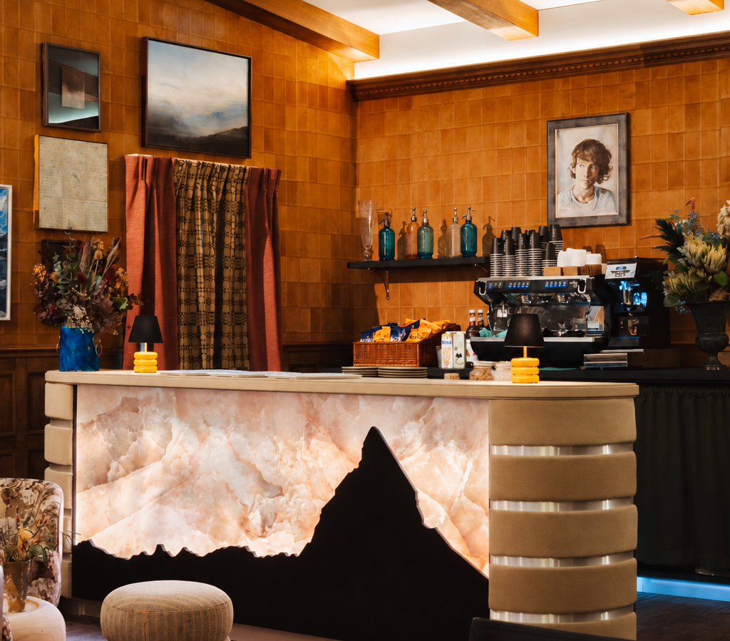 Alpine-inspired Decorex 2026 VIP Lounge by Claudia Dorsch, featuring exposed timber beams, sculptural lighting and an illuminated LumiStone bar front.