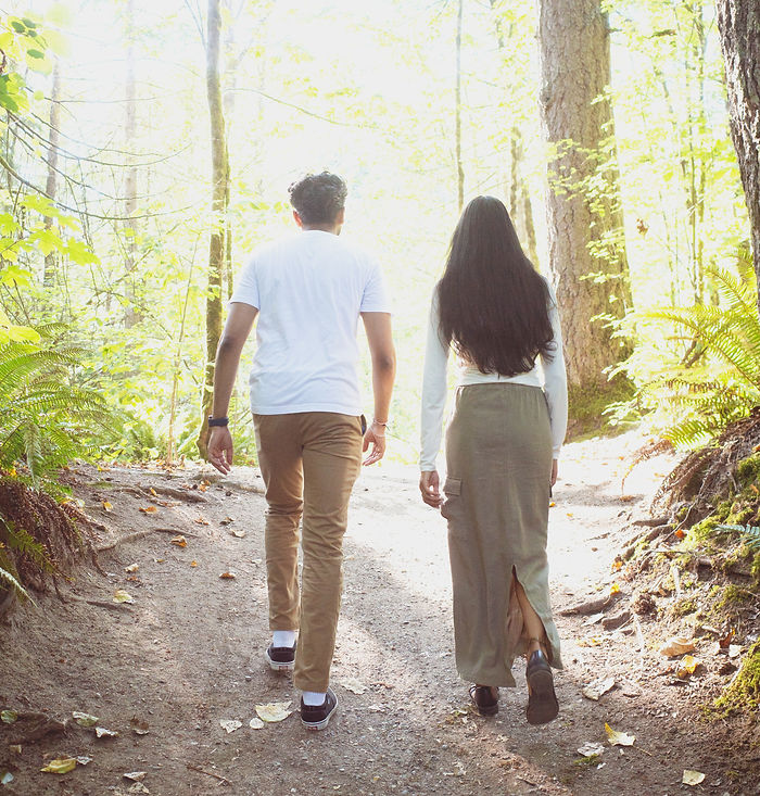 Two individuals walking on a path in the forrest