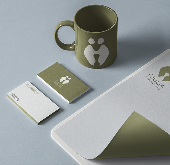 Green mug and stationery with abstract logo design.