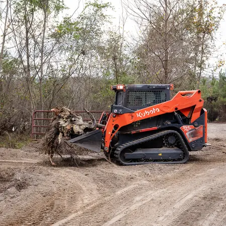 Final brush and debris removal using a compact track loader.”