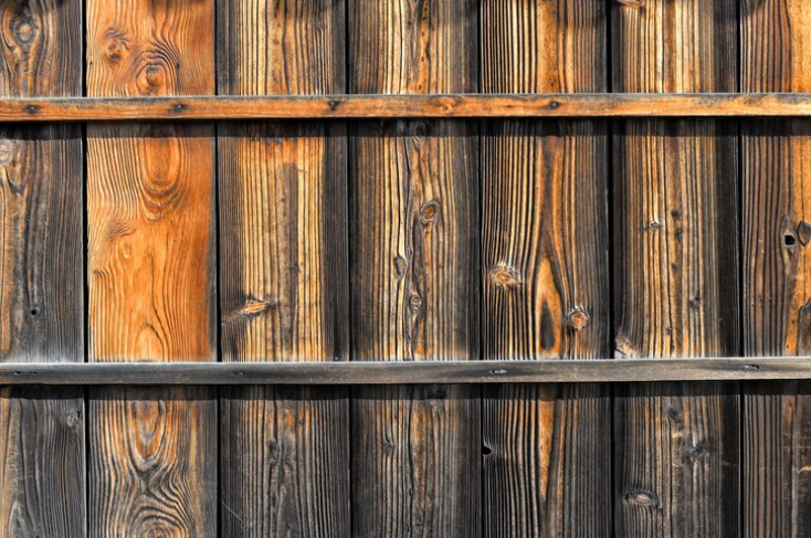 Rotting timber fencing due to prolonged moisture exposure and ageing materials