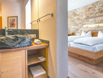 Mineralien-themed hotel room interior with pine-wood bed and mineral accents