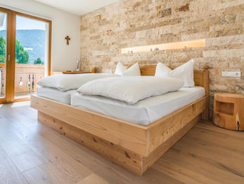 Mineralien-themed hotel room interior with pine-wood bed and mineral accents