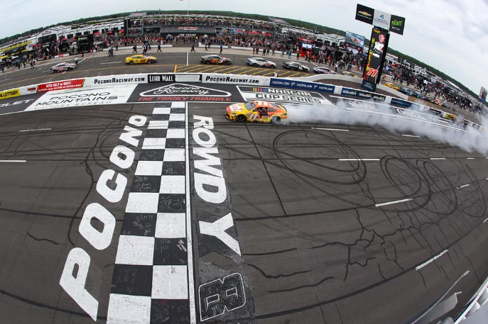 Denny Hamlin celebrates his win in the Great American Getaway 400 at Pocono Raceway. (Photo: James Gilbert/Getty Images)