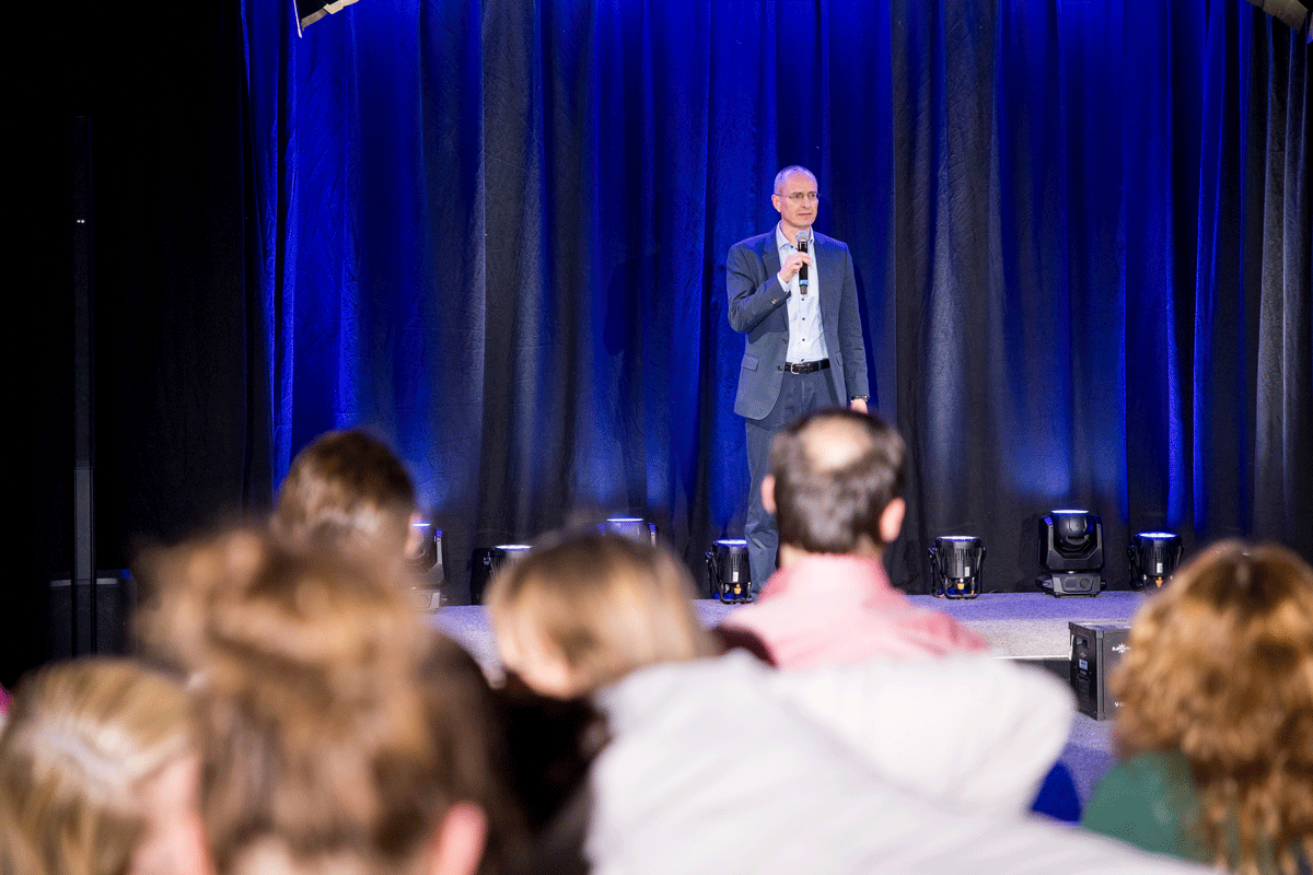 Oliver Wunsch beim Speaker Slam in Wiesbaden – Impulsvortrag über Mindset-Stärkung und mentale Klarheit vor großem Publikum. Foto aus dem Zuschauerraum mit Blick auf die Bühne.