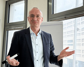Nahaufnahme von Oliver Wunsch im Coaching-Setting vor dem Flipchart – im Gesprächsmodus mit offener Körperhaltung. Sinnbild für persönliche Weiterentwicklung, Selbstführung und MindShift.