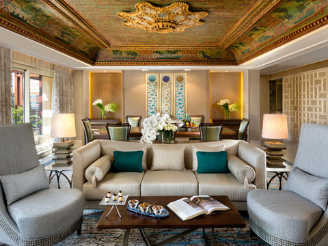 Luxurious Presidential Suite interior with spacious living and dining areas, ornate ceiling, and wall panels