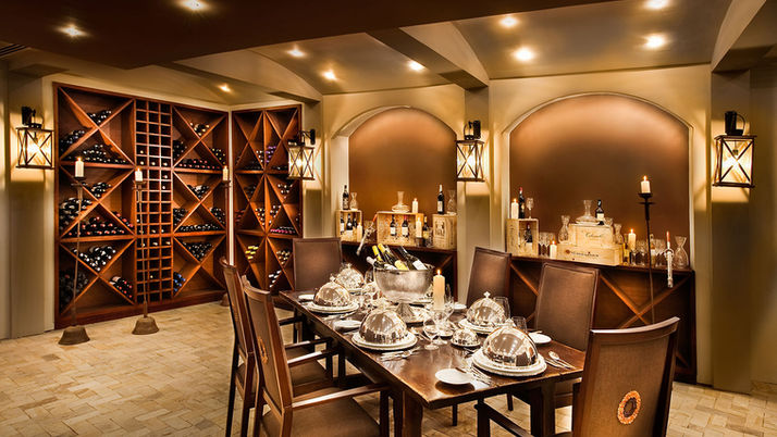 Luxury hotel wine cellar with wooden bottle racks and private tasting table.