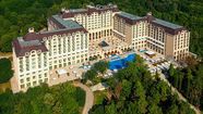 Aerial view of Meliá Grand Hermitage hotel in Golden Sands, Bulgaria, surrounded by green parkland and forested hills.