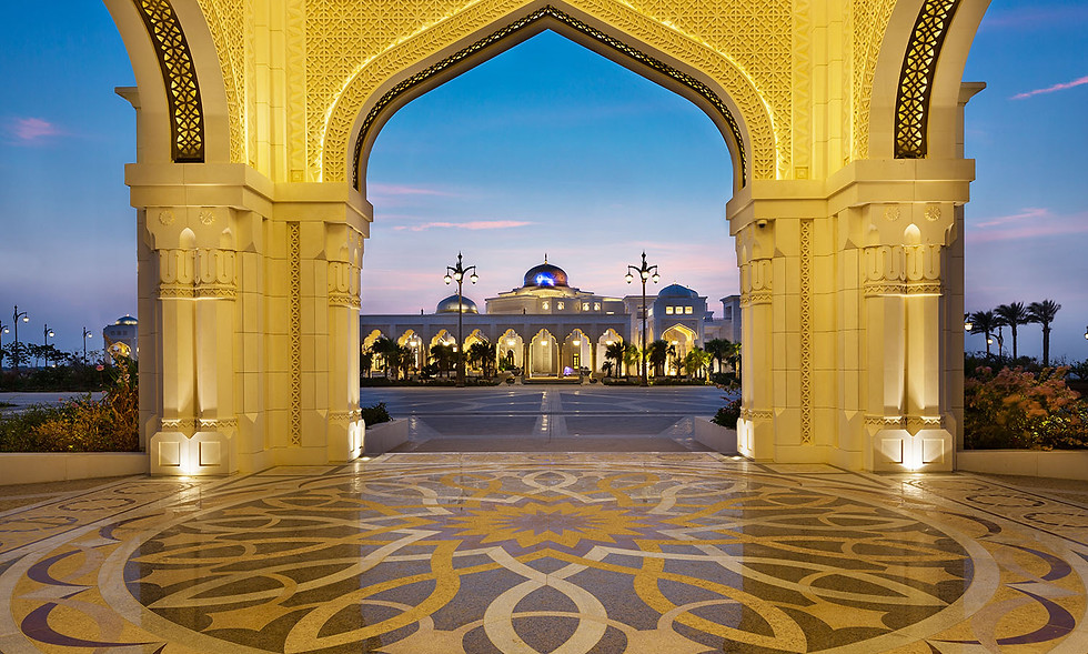 Ornate golden archway framing Qasr Al Watan Palace in Abu Dhabi at dusk beneath a twilight sky.