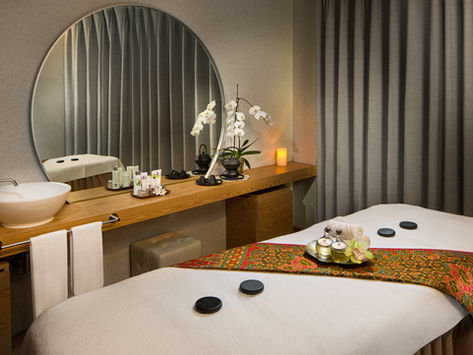 Spa treatment room featuring massage tables and floral decor