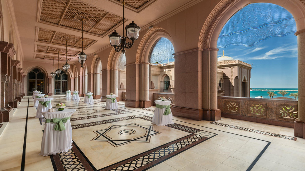 Luxurious hotel hallway with elegant tables and ornate arches.