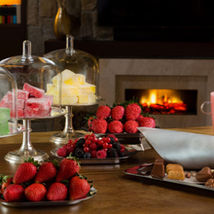 Luxurious dessert spread at the Kempinski Hotel Mall of the Emirates, set against a cozy fireplace backdrop. A perfect blend of elegance and comfort