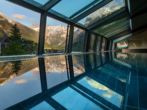 Bright indoor pool with mountain scenery and reflective water