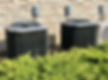 Two Heating Ventilation and Air Conditioning or HVAC Condenser Units Stand Next To an Exte
