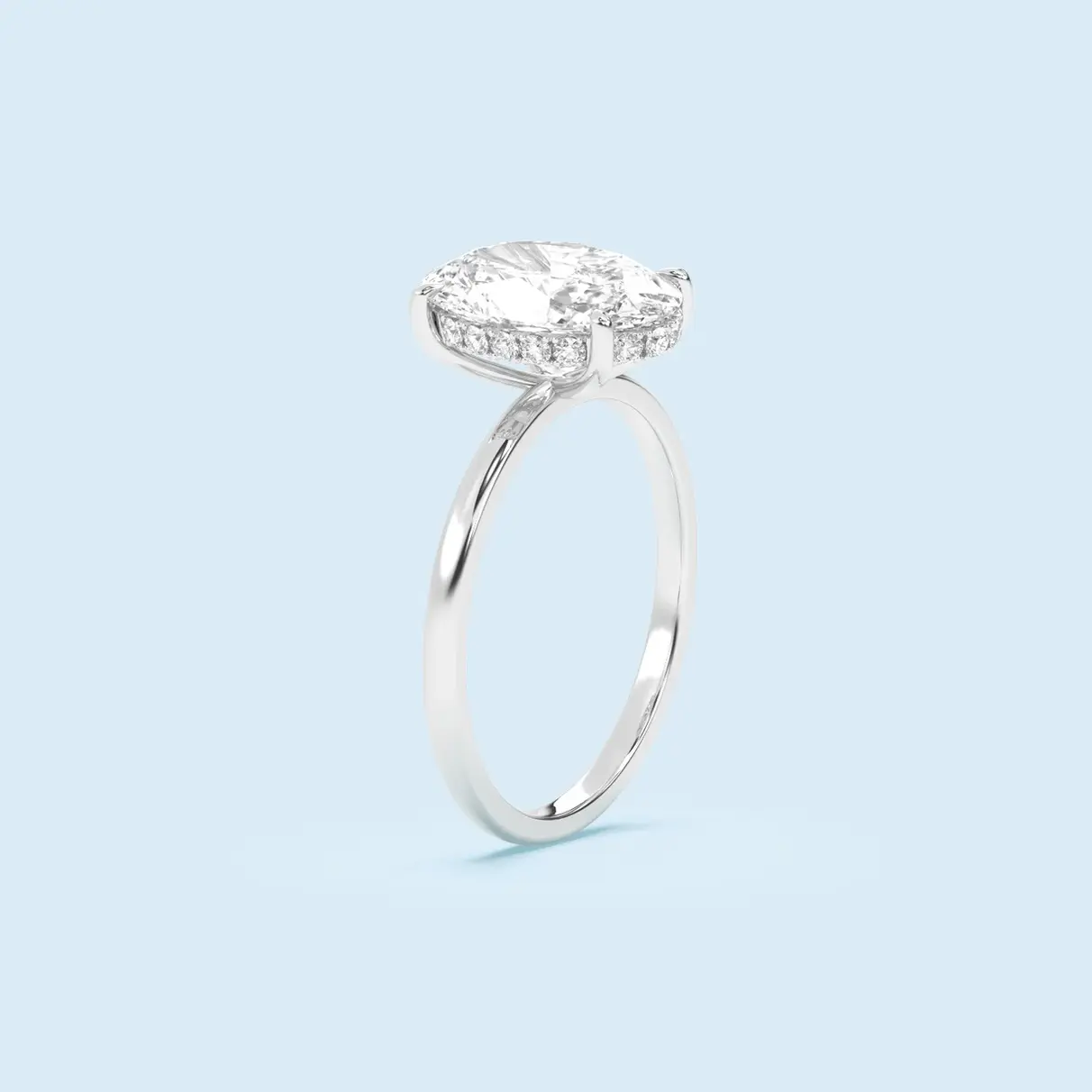 Pierścionek solitaire z owalnym diamentem, osadzonym na smukłej obrączce z białego złota.