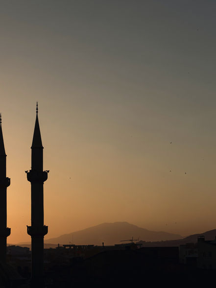 A mosque with minarets in the sunset sky
