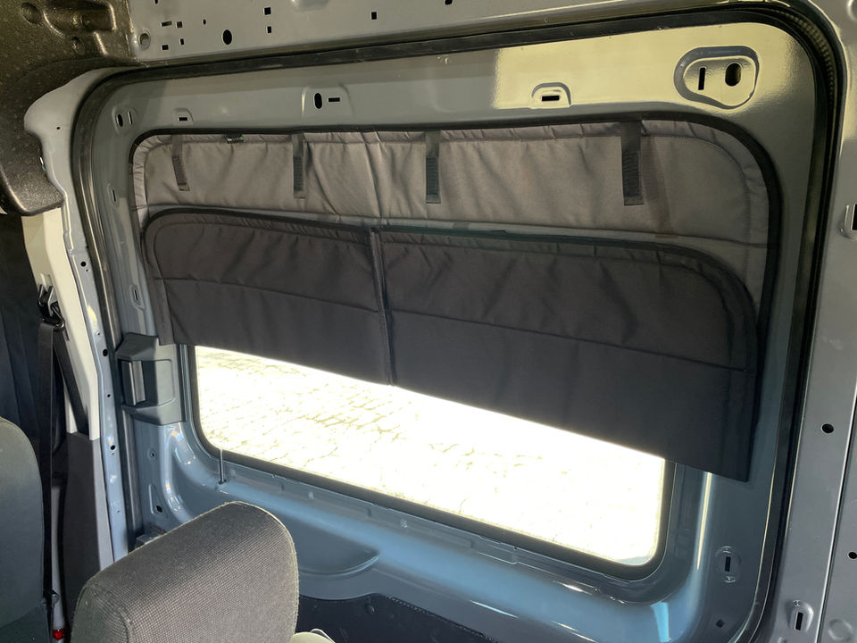 Van window with installed VanEssential rear panel shades