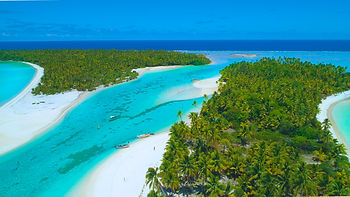 Aerial view of lush palm trees, white sand beaches, and turquoise waters surrounding One Foot Island (Tapuaetai) in Aitutaki.