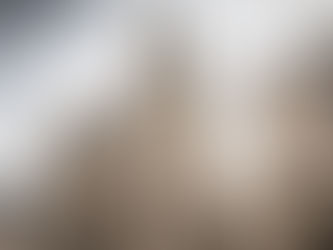 A low-angle photo of the Leuven Town Hall (Stadhuis), a stunning example of Brabantine Late Gothic architecture in Belgium, featuring intricate stone lace detailing, numerous spires, and statues. The sky is bright and overcast. A diagonal banner graphic reads "Where Ancient Soul Meets Modern Spark in Leuven, Belgium."