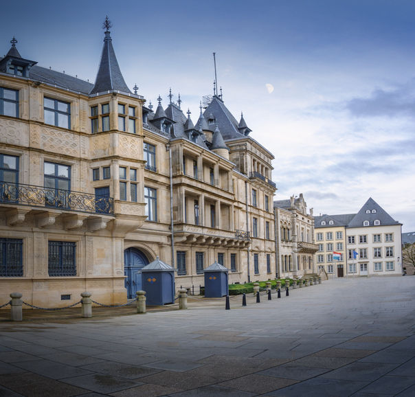 Front facade of the ornate Renaissance-style Grand Ducal Palace featuring turrets and guard booths along a cobblestone square