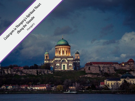 A striking photo of the Esztergom Basilica, a large, domed cathedral in Hungary, standing on a hill above the Danube River. The sky is dramatic with dark clouds, and the basilica's facade is illuminated by a warm, golden light. A banner in the top left corner reads, "Esztergom is Hungary's Spiritual Heart Along the Danube, Hungary." The photo is taken from the opposite bank of the river, showing the town and the river's surface in the foreground.