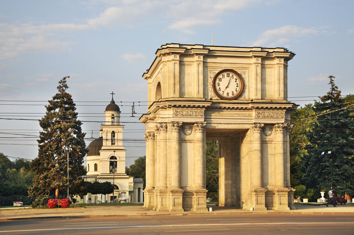 Triumphal Arch in Chisinau, Moldova with the Nativity Cathedral in the background, captured on a sunny day.