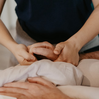 Pflegende Hände berühren den Patienten