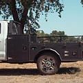 Custom hybrid flatbed truck bed with front storage boxes and open rear deck