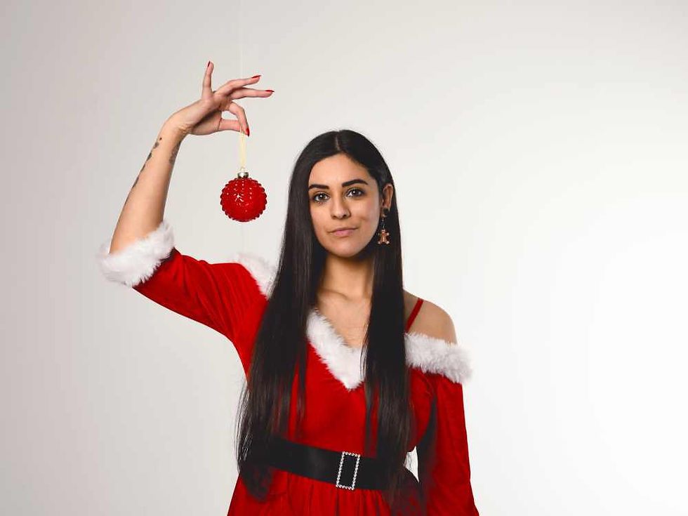 Misuzu in a red Miss Santa outfit holding a red bauble up, smiling.