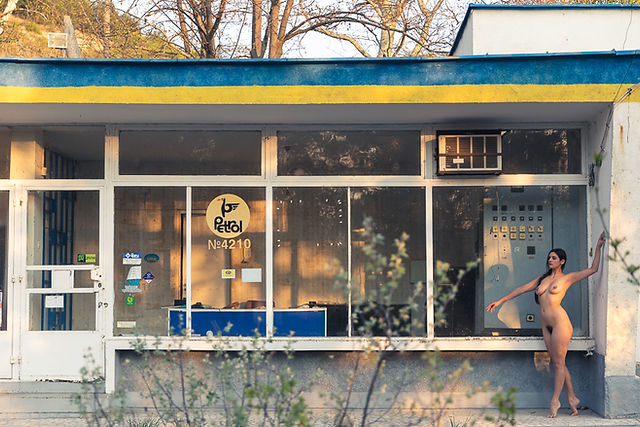 Misuzu nude in front of an abandoned petrol station a sunset