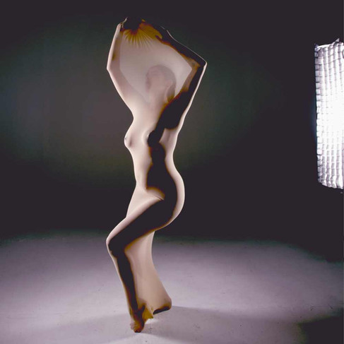 Misuzu standing in the cocoon body stocking with a studio light in frame