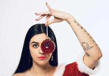 Misuzu holding a red bauble in front of one eye
