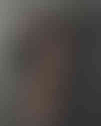 Misuzu wearing a black lace bodysuit, stood in front of a corrugated iron back ground