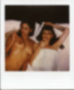 Polaroid of Misuzu and Stacie Mai smoking in bed. Misuzu is nude and Stacie is under white bedcovers