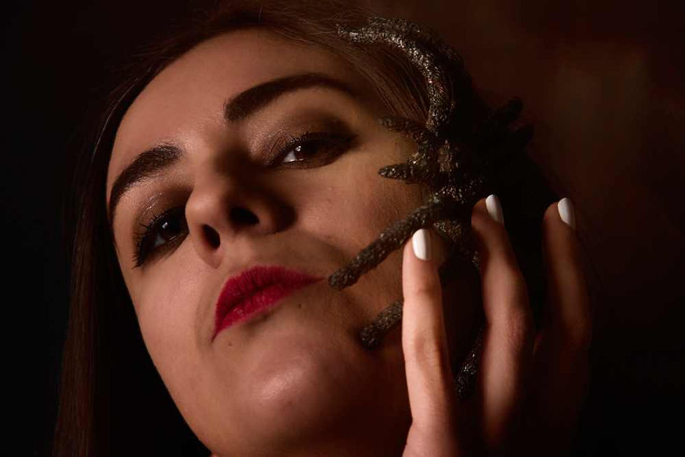 Close up portrait of Misuzu with a giant spider on her face