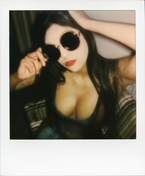 A Polaroid of Misuzu wearing latex and sunglasses