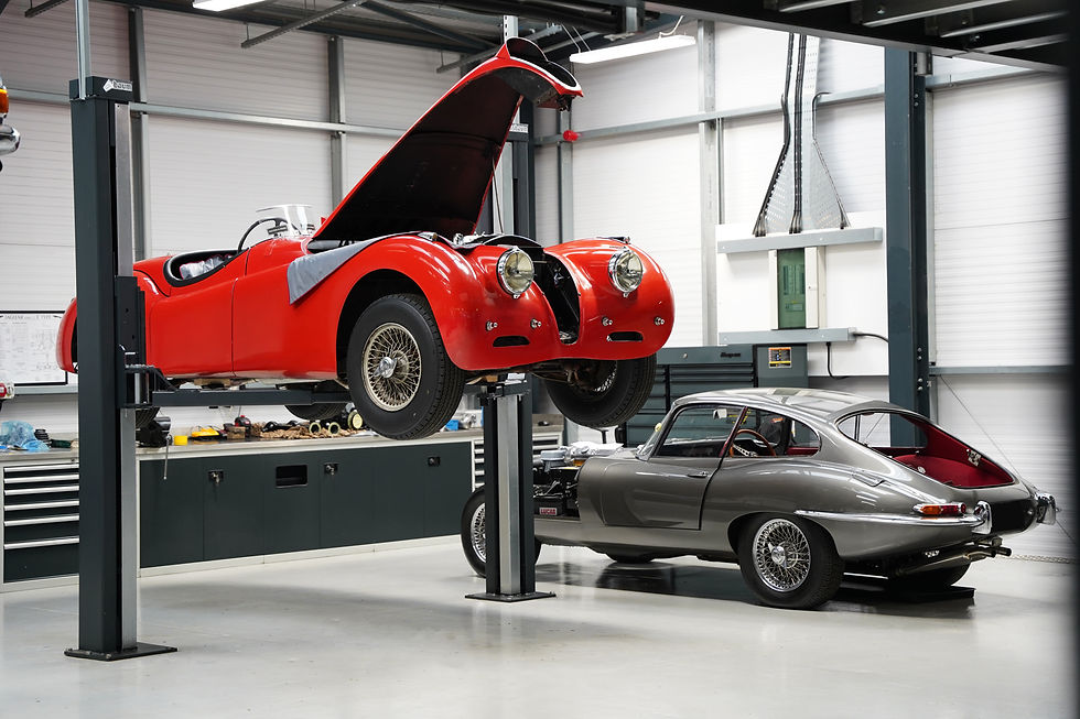 Jaguar XK and Jaguar E-type having work done inside the Hilton and Moss garage