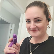 A woman with a purple spray bottle in hand, prepared to tackle cleaning tasks with ease and efficiency.