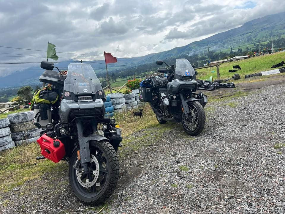Eye-level view of adventure motorcycle with panniers and tank bag parked on a dirt road