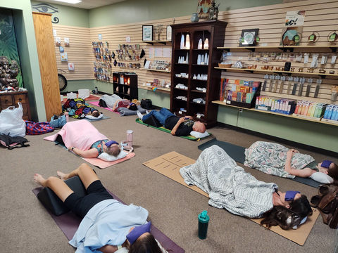 People taking part in Yoga Nidra and Sound Healing are covered with blankets in a peaceful indoor session.