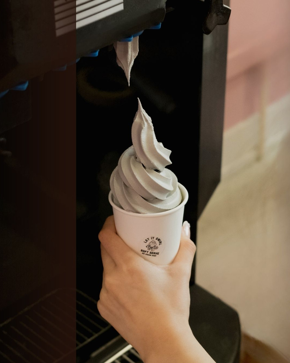 Black sesame soft serve gelato being swirled fresh from the machine into a Let It Swirl cup