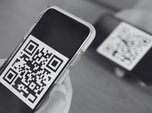 Person holding mobile phone showing QR code